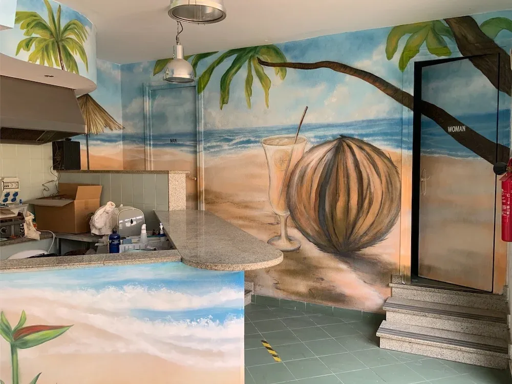 Mural tropical de playa en la zona de barra de un restaurante