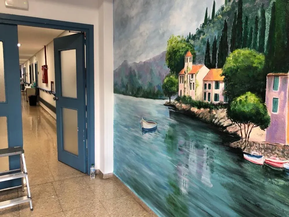 Artista pintando un paisaje mural en directo